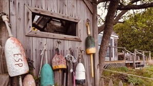 A rustic wooden structure with various fishing equipment hanging on the exterior wall. - Lovely Waterfront Suite near Portsmouth (Dover)