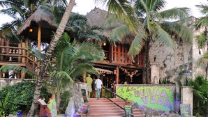 A restaurant with a staircase leading to a wooden deck, surrounded by palm trees and a stone wall. - Akumal Paradise Private Studio - WiFi, Air Conditioning (Akumal, Riviera Maya)