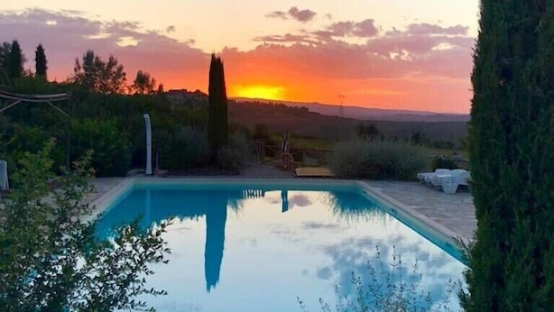 A rectangular swimming pool with a stone border, surrounded by greenery and a tall tree. - Beautiful house near San Gimignano in Tuscany with views, pool,garden, A/C, WiFi (Gambassi Terme, FI)