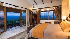 A spacious bedroom with a large bed, a television, and a view of the outdoors. - Platinum - A New level of Luxury, with 360 degree views & unmatched quality (Quepos)
