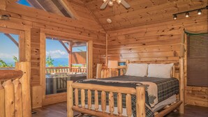A wooden cabin bedroom with a bed, a window, and a ceiling fan. - 🐾Paradise Point 🏔️LeConte Views, Hot Tub, Resort Pool! Near Attractions! (Sevierville)