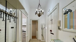 A hallway with a patterned floor, a chandelier, a mirror, and a telephone. - Da Zio Giovanni - 2 steps from the sea (Pescara)