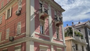A pink building with white trim, multiple windows with shutters, and a balcony with a metal railing. - Da Zio Giovanni - 2 steps from the sea (Pescara)
