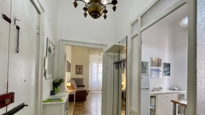 A hallway with a patterned floor, a sofa, a radiator, and a refrigerator in the background. - Da Zio Giovanni - 2 steps from the sea (Pescara)