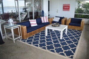 A living room with wicker furniture, a white coffee table, and a patterned rug. - Lake June Zen Retreat (Lake Placid)
