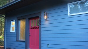 A house with a red door, a small window, and a number '4051' on the wall.