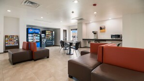 A lobby with seating areas, a Pepsi vending machine, a microwave, and a small kitchenette. - Studio 6 Corpus Christi, TX (Corpus Christi)
