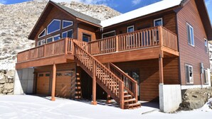 A two-story wooden cabin with a balcony and a staircase. - Yellowstone Northern Views -- Gorgeous Home. One mile to Yellowstone! (Gardiner)