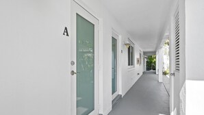 Un pasillo con paredes y puertas blancas, que conduce a habitaciones.