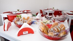 A buffet setup with various food items in baskets and trays, arranged on tables with red and white tablecloths. - B&B Etna's Tourist (Catania)
