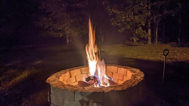 A circular fire pit with a brick design, surrounded by grass. - Warm Springs Retreat (Warm Springs)