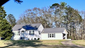 A two-story house with a front porch, a garage, and a small attached shed. - Warm Springs Retreat (Warm Springs)