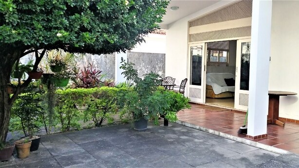 A patio with potted plants, a table, and a chair. - Casa Maceio Shopping (Maceió)