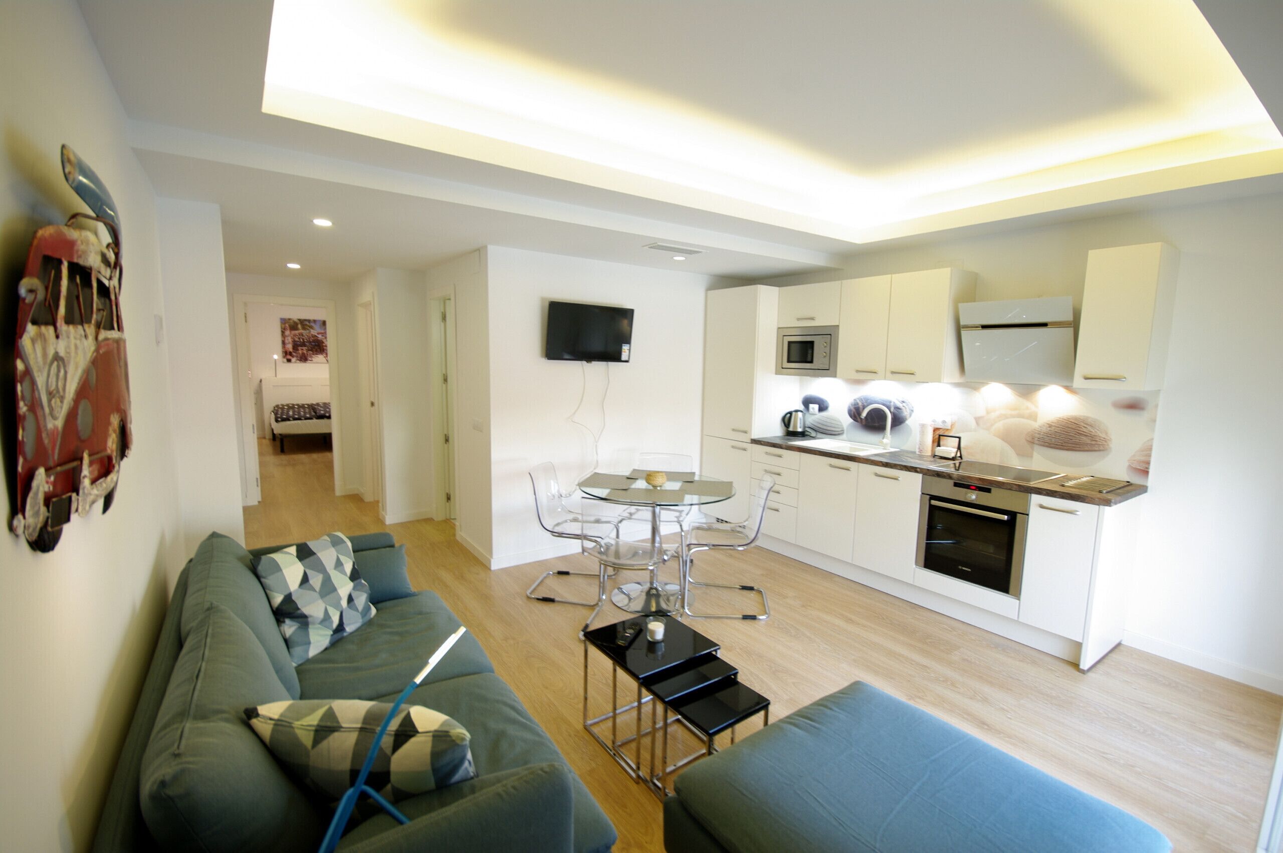 A modern apartment with a living room, dining area, and kitchenette.