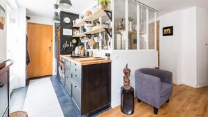 Eine moderne Küche mit einer zentralen Kochinsel, Holzschränken und diversen Küchenutensilien.