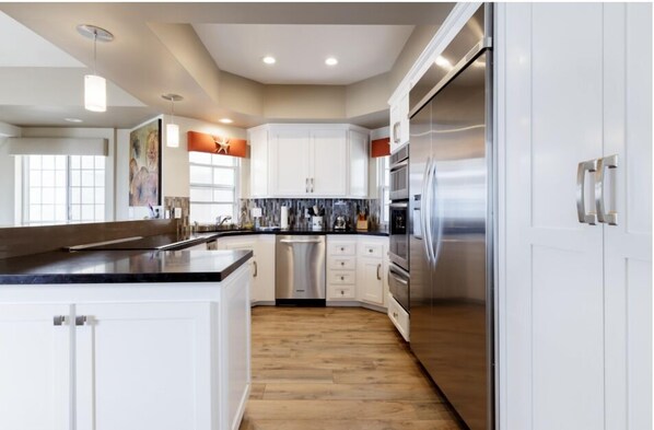 Enjoy cooking in this well-equipped kitchen with a central island, stainless steel appliances, and a dishwasher.