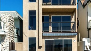 Een modern gebouw met meerdere verdiepingen, een plat dak, grote ramen en een gevel van natuursteen.