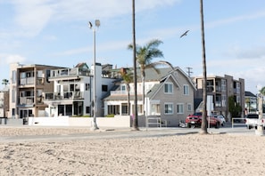 Une propriété située en bord de mer, avec des bâtiments à plusieurs étages, une plage de sable et des palmiers.
