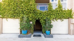 Una entrada de garaje con un arco cubierto de hiedra verde.