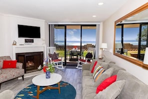 Cozy living room with a fireplace, flat-screen TV, and ocean views.