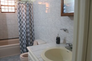 A bathroom with a bathtub, toilet, and sink. - La Gaviota (Gros Islet)