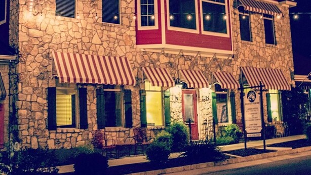 A two-story building with a stone facade and red and white striped awnings. The sign on the building reads "High Cotton Inn." - High Cotton Inn (New Braunfels)