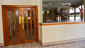 A wooden door with a glass panel and a sign above it. - Hotel Baeza (Delicias)
