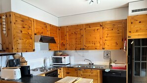 A kitchen with wooden cabinets, a stove, a microwave, a sink, and a dishwasher. - Outside : 3-room flat for 4 persons on the 1st floor, large terrace with garden furniture.Inside : e (St-Luc)