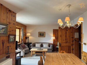 A cozy living room with a wooden floor, a sofa set, a coffee table, and a chandelier. - Saint-Luc is accessible all year round from Sierre by car or bus. However, the Val d'Anniviers is a (St-Luc)
