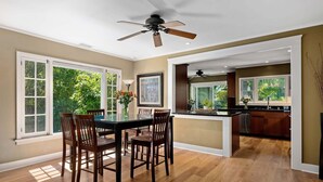 A spacious kitchen with a dining area, large windows, and a ceiling fan. - Charming Home w/ Private, Enclosed Yard, Easily Accessible to All of SB! (Santa Barbara)