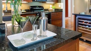 A kitchen counter with a white tray holding a martini glass, a cocktail shaker, and a vase with flowers. - Charming Home w/ Private, Enclosed Yard, Easily Accessible to All of SB! (Santa Barbara)