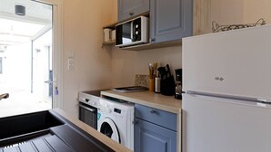 Eine kompakte Küche mit Waschmaschine, Mikrowelle und Kühlschrank.
