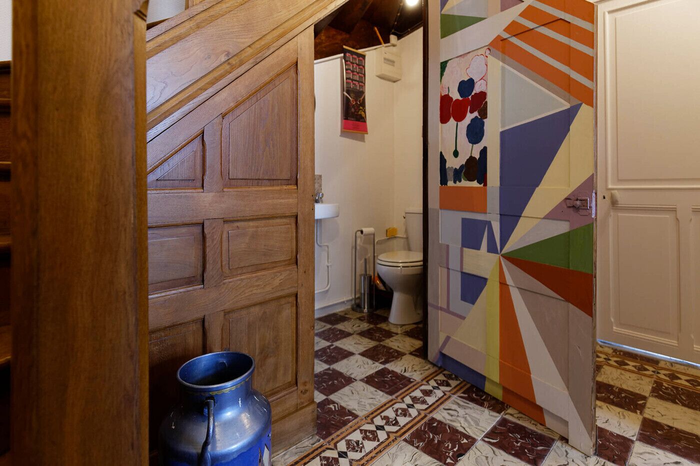 Un baño con piso de baldosas, inodoro y zona de ducha.