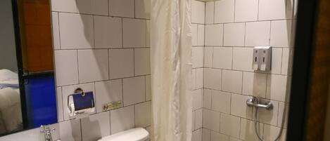 Un baño con lavamanos blanco, inodoro y zona de ducha.