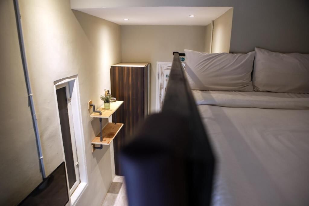 A bedroom with a bed, a bedside table, and a small cabinet.