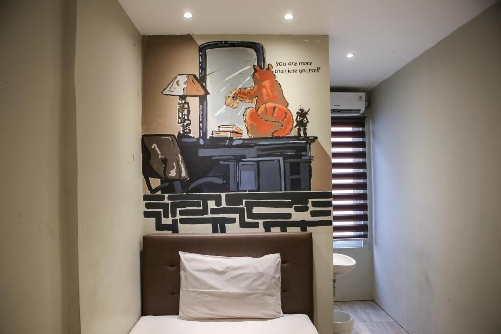 A bedroom with a bed, a wall-mounted mirror, and a motivational quote.