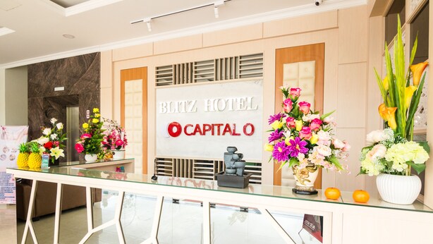 A reception desk at the Blitz Hotel with a marble wall and a sign that reads "Blitz Hotel Capitalo". - Blitz Hotel Batam Centre (Batam)