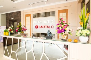 A reception desk at the Blitz Hotel with a marble wall and a sign that reads "Blitz Hotel Capitalo". - Blitz Hotel Batam Centre (Batam)