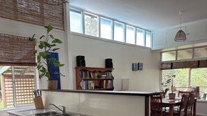 Una cocina moderna con una isla central, armarios de madera y un comedor con mesa y sillas.