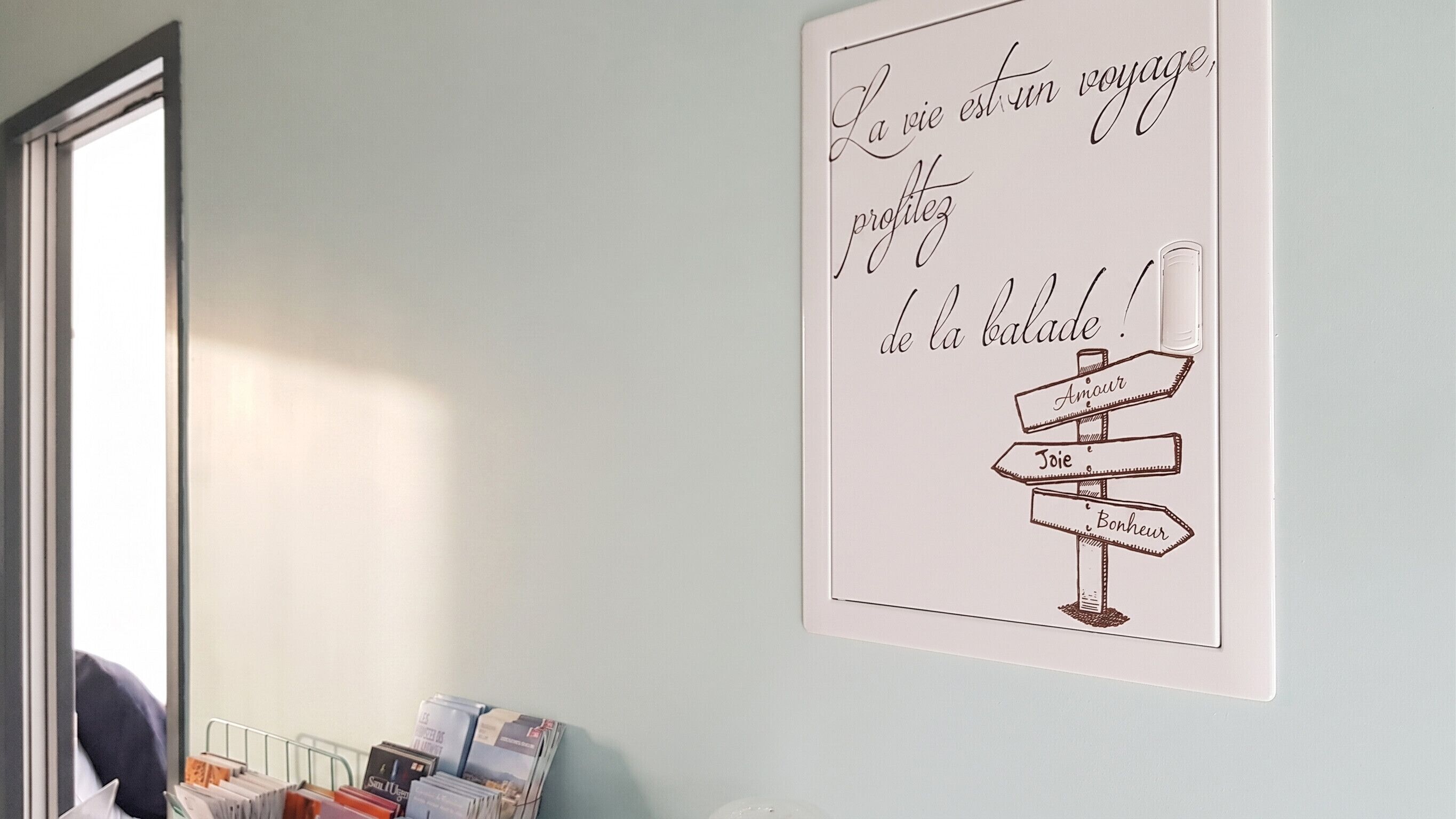 Una pared con una ilustración de un cartel y una ventana con persianas.
