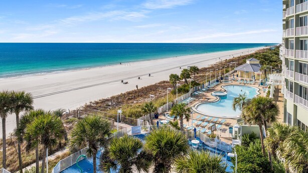 Un resort con piscina, playa y vista al océano.