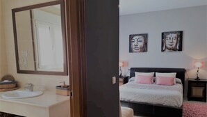 A modern bedroom with a large bed, bedside tables, and artwork on the wall.