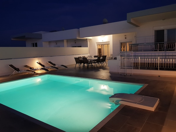 A rooftop swimming pool with lounge chairs and a dining area, surrounded by a modern building with balconies. - VILLA DIONYSOS - HESTIA - KOS -GRECE - 8 persons - private pool (KOS)