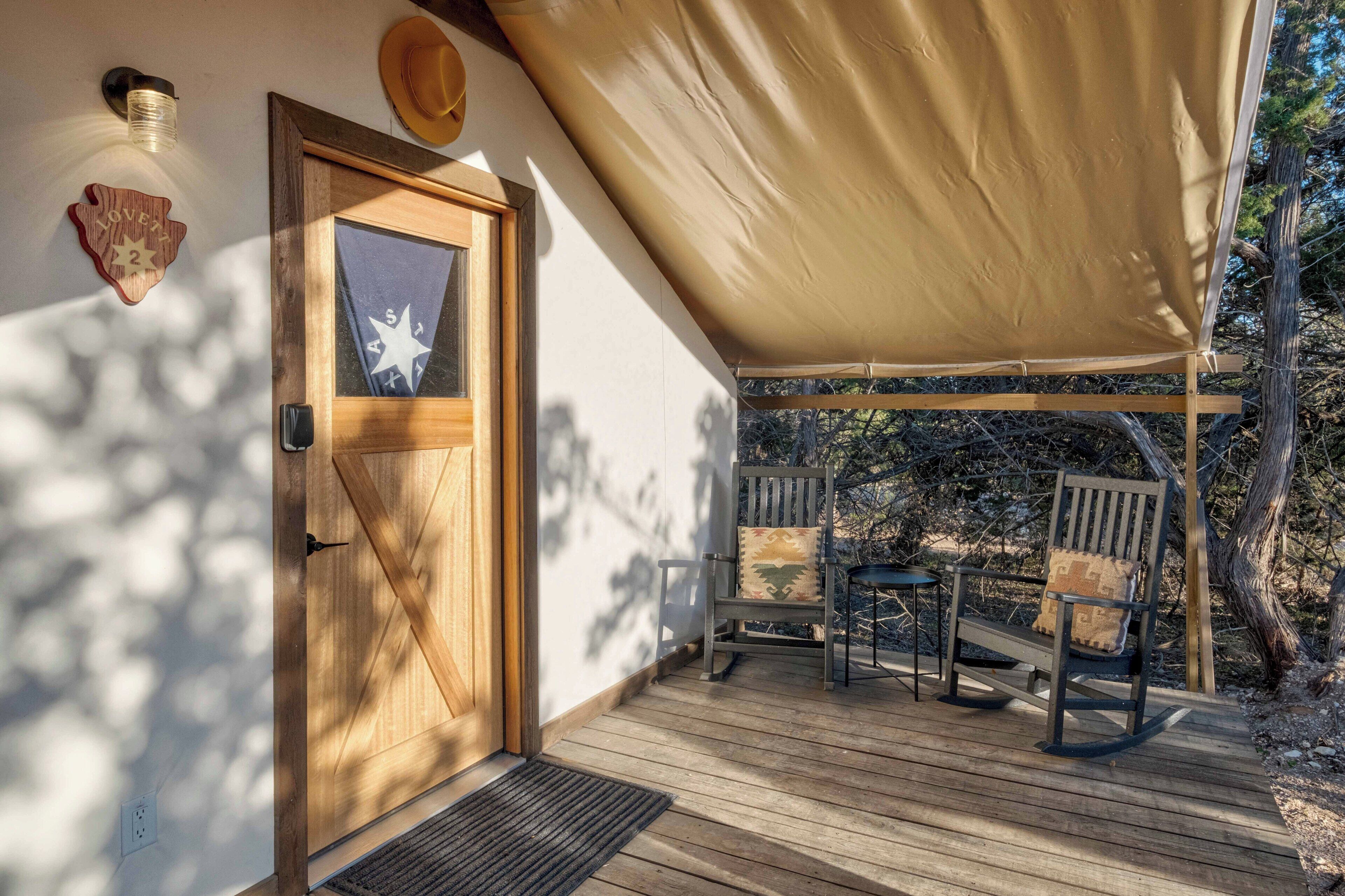 A wooden door with a star-shaped window, a wooden bench, and a canopy over a porch.