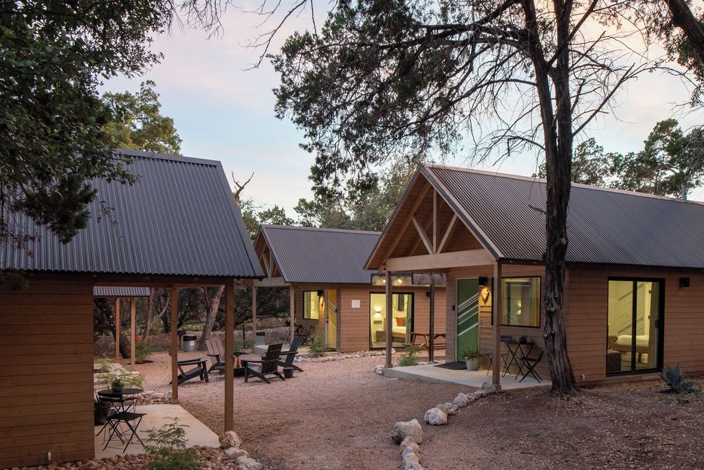 A lodge with multiple cabins, outdoor seating, and a covered patio area.