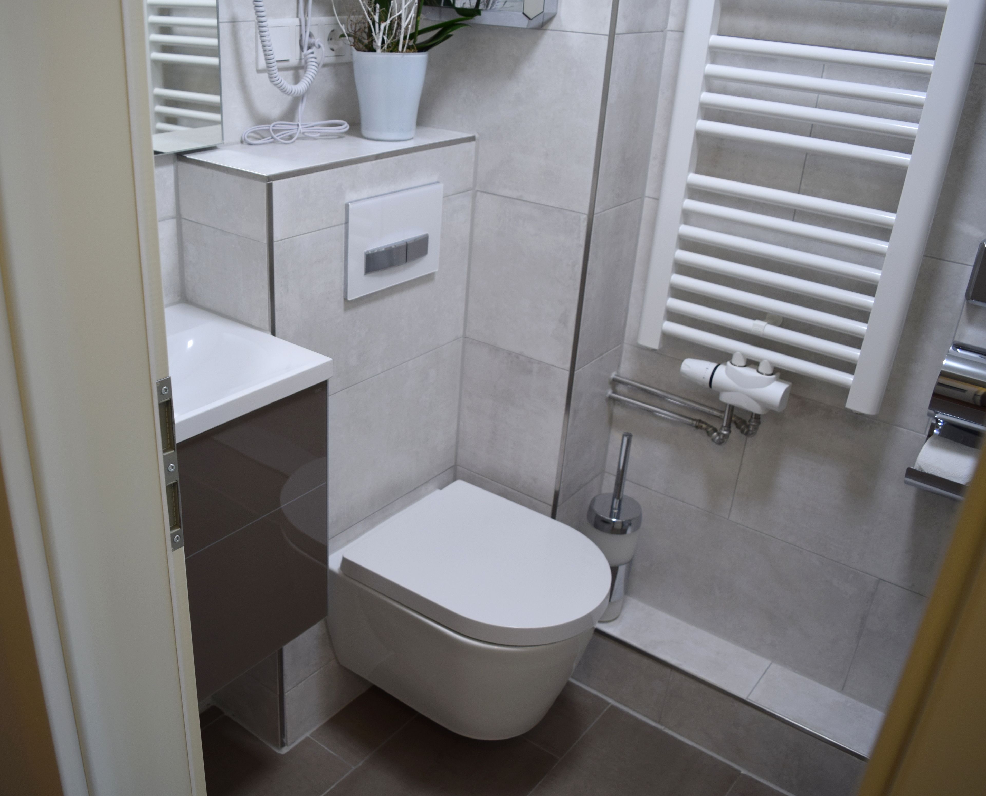 Une salle de bain moderne équipée de toilettes, d’un lavabo et d’une zone douche.