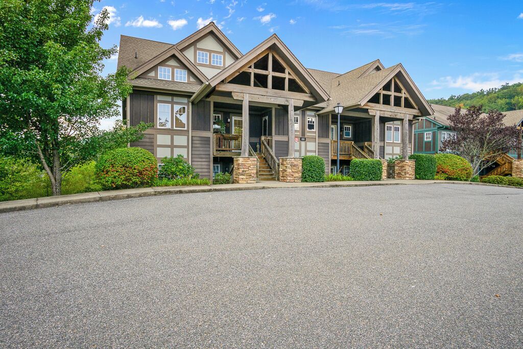 A multi-story building with a central entrance, stone pillars, and a covered porch.