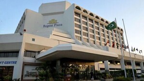 A hotel named Regent Plaza with a modern architectural design, featuring a prominent entrance and multiple flags. - Regent Plaza Hotel & Convention Centre (Karachi)