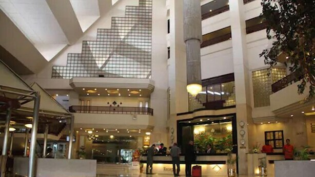 A spacious lobby with a high ceiling, a reception desk, and a staircase leading to upper floors. - Regent Plaza Hotel & Convention Centre (Karachi)