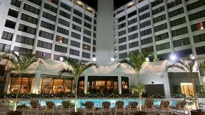 A hotel with multiple floors, a swimming pool with lounge chairs, and string lights. - Regent Plaza Hotel & Convention Centre (Karachi)